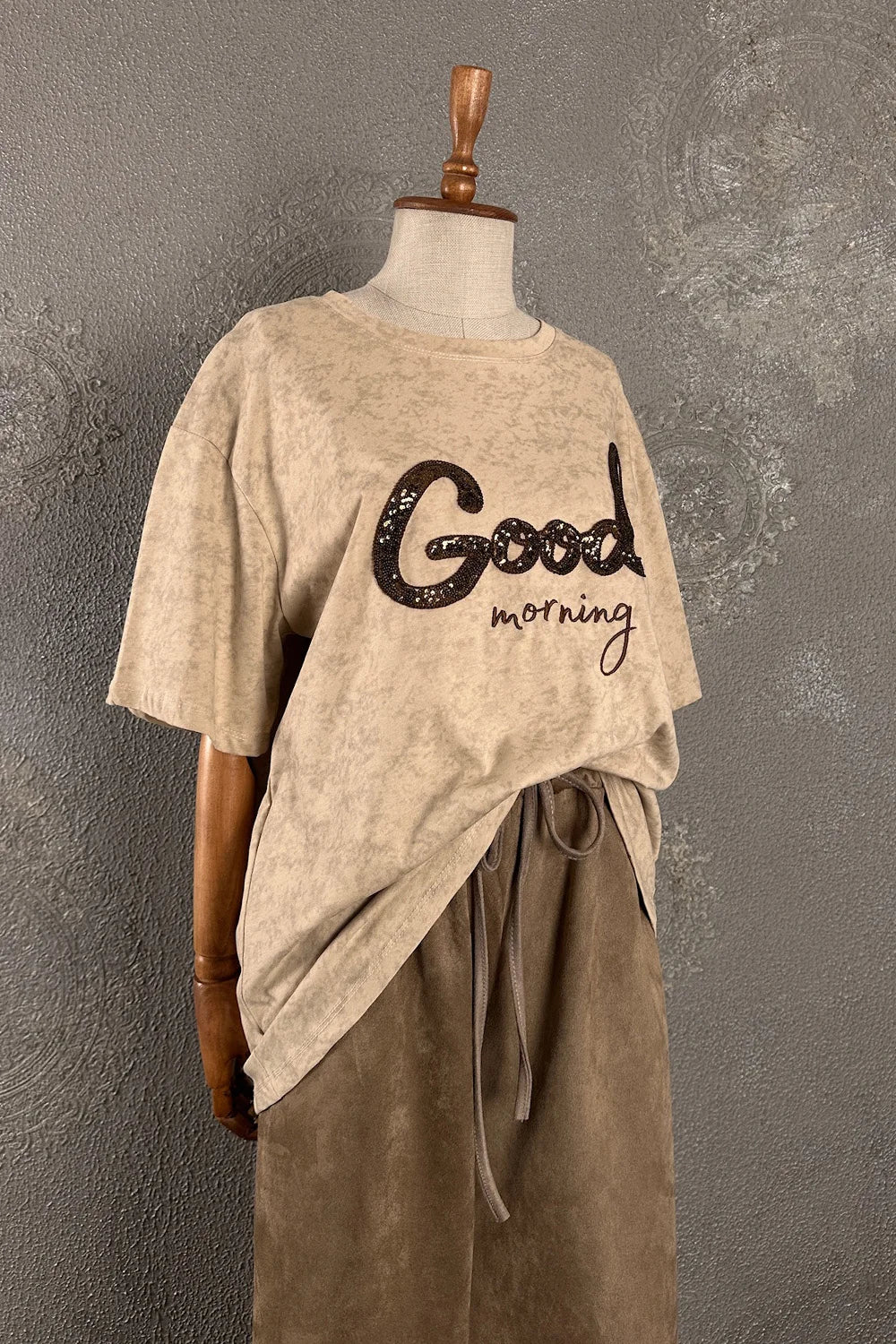Krem melanj kadın t-shirt, Good morning baskılı, oversize kesim, yandan asimetrik drape detaylı, önden görünüm