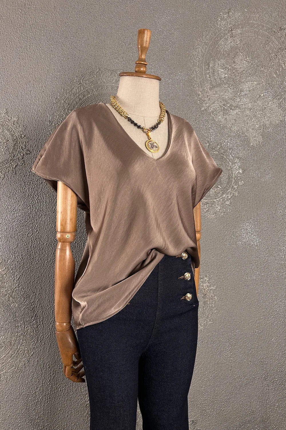 Taupe saten v yakalı kadın bluz, kısa kollu, önden drape detaylı, siyah pantolon ile kombinli görünüm.