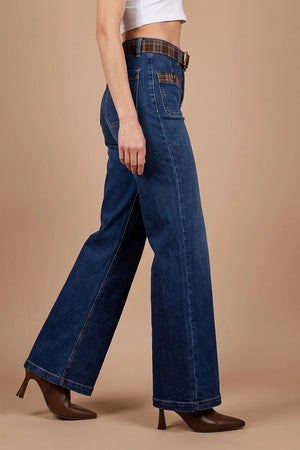 Ekose detaylı düz paça kadın jeans, koyu mavi denim, geniş kesim, yandan görünüm, kahverengi topuklu ayakkabı ile