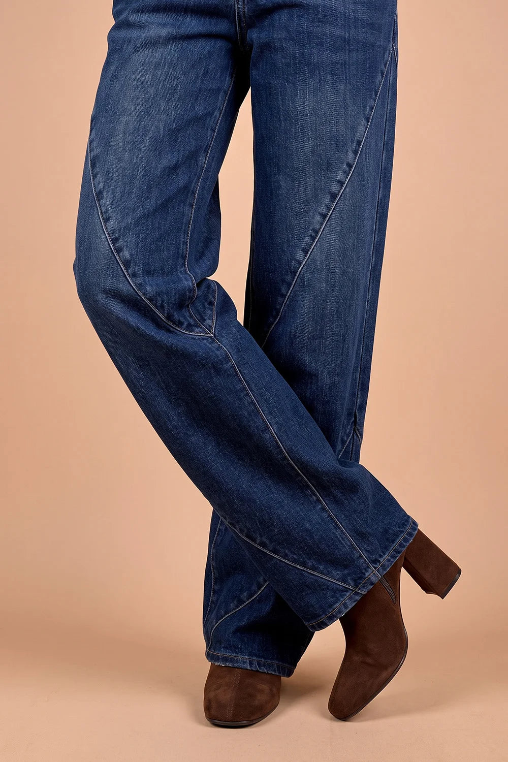 Koyu mavi geniş paçalı kadın jeans, kahverengi süet bot ile stilize, yandan detay görünüm
