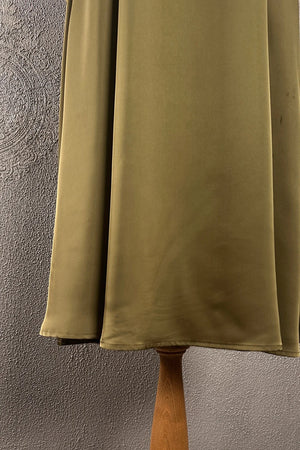 Krem saten kadın elbise, yumuşak drape detaylı, uzun kesim, yandan görünüm, ahşap askılı manken üzerinde