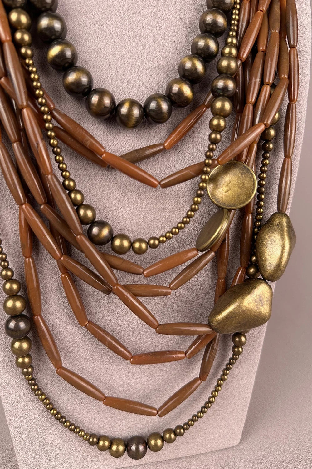 Bohem katmanlı boncuk kolye, bronz ve kahverengi tonları, metal ve ahşap detaylı, çok sıralı kadın aksesuar, önden görünüm.