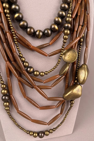 Bohem katmanlı boncuk kolye, bronz ve kahverengi tonları, metal ve ahşap detaylı, çok sıralı kadın aksesuar, önden görünüm.