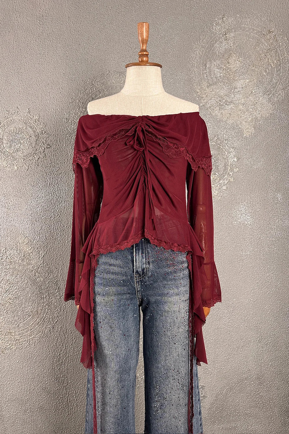 Bordo dantel detaylı romantik bluz, kadın off-shoulder kesim, asimetrik uzun kollu, ipli bağlama detaylı, önden görünüm