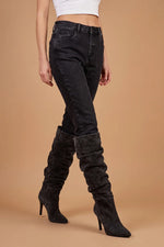 Siyah skinny jean ve deri over-the-knee çizme kombinasyonu, kadın yüksek bel kesimi, yandan görünüm