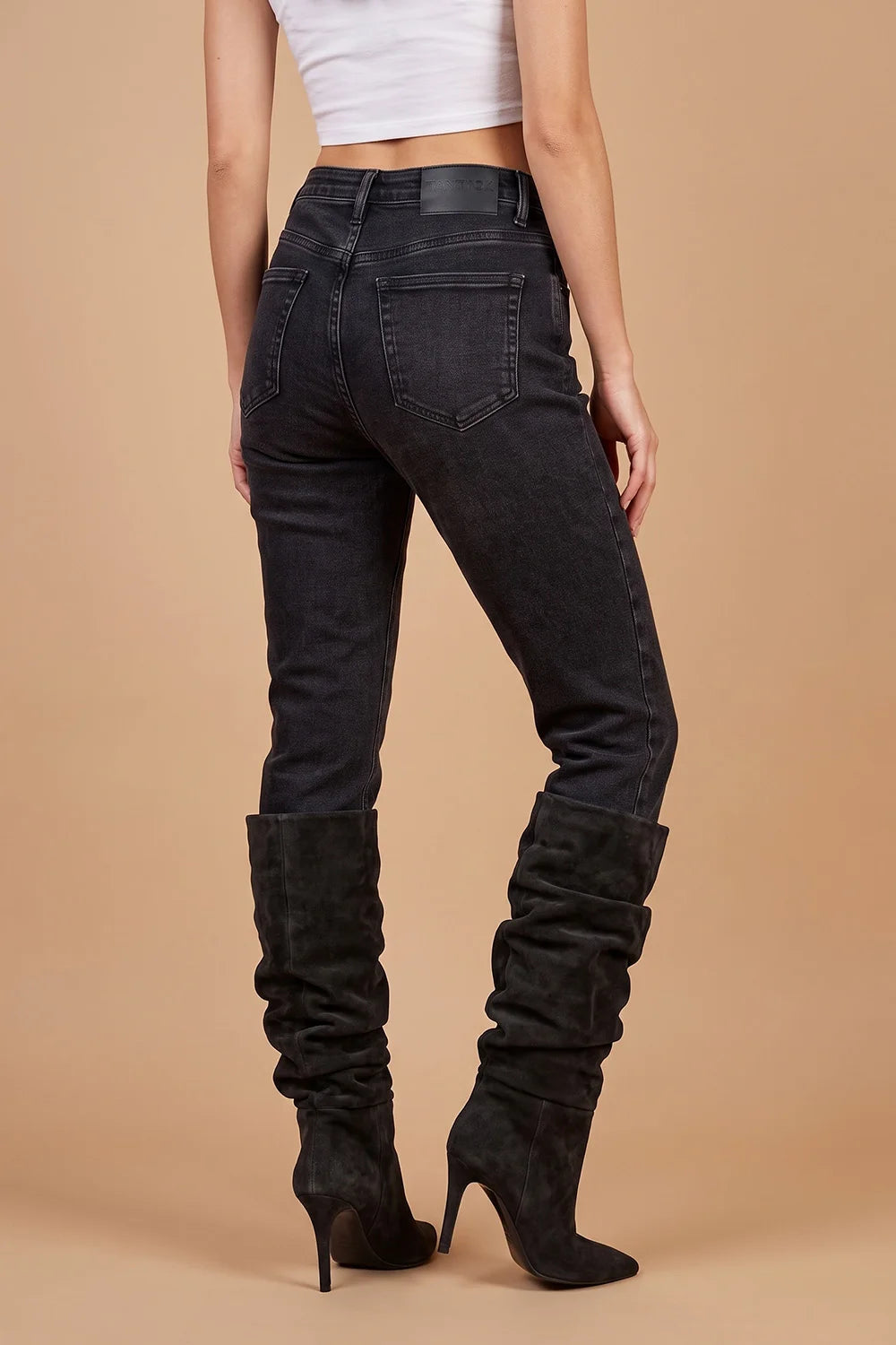 Siyah yüksek bel skinny jean, dar kesim, uzun suet çizme ile yandan görünüm, kadın denim pantolon