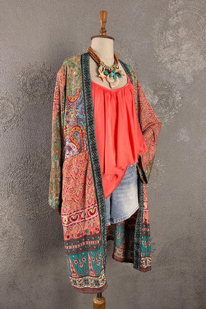 Çok renkli ipek kimono, paisley ve çiçek desenleri, açık mercan bluz, denim pantolon, kadın boho tarzı, uzun kesim, önden görünüm.