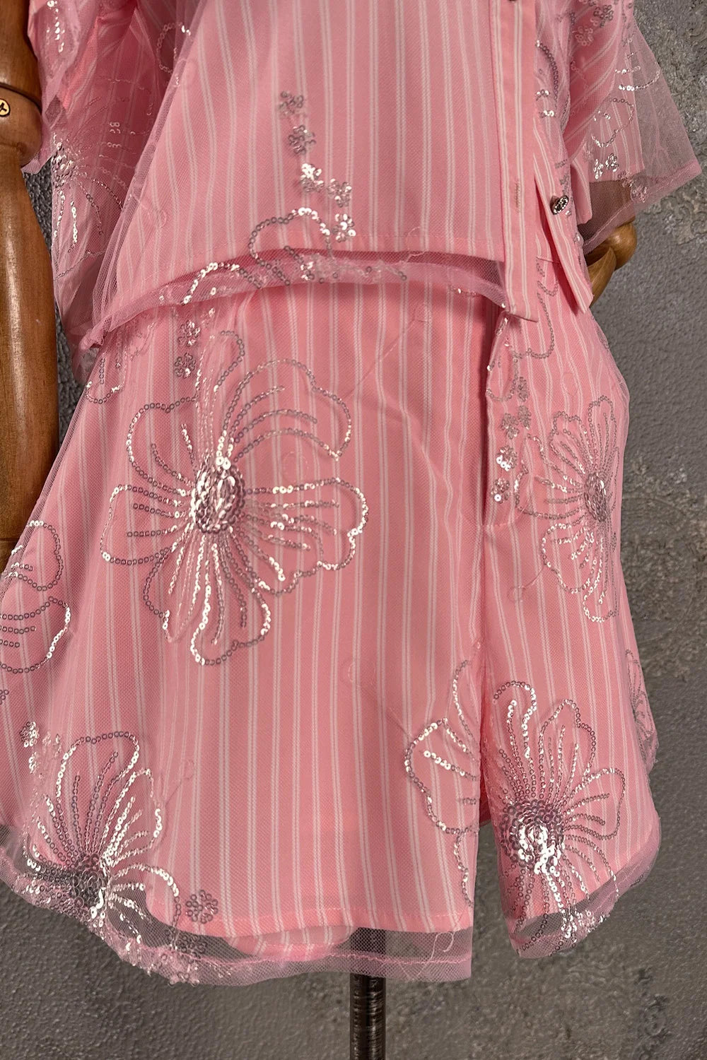 Pembe işlemeli şort takım, çiçek detaylı, transparan tül overlay, pileli kesim, detay görünüm.