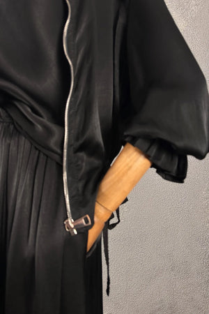 Siyah ipek saten büzgülü kadın ceketi, gümüş fermuarı ve çekme detayı ile, yandan görünüm.