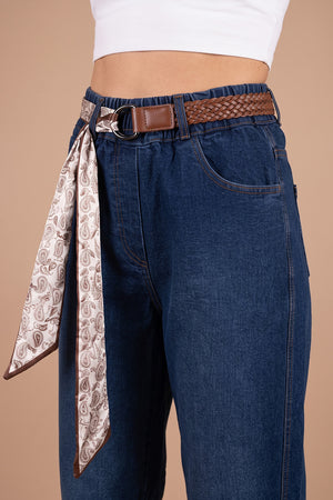 Lacivert barrel jean, kahverengi örgü kemer ve paisley desenli fular detaylı kadın pantolonu, önden görünüm.