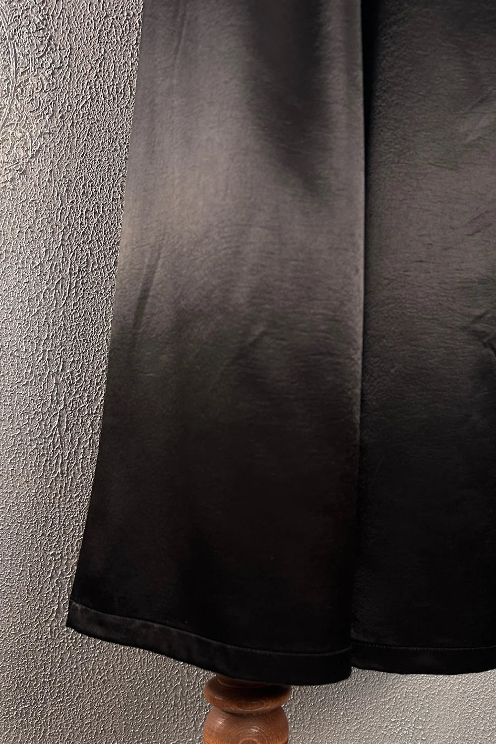 Siyah saten kadın pantolon, düz kesim, yumuşak dokulu kumaş, ayak detayı, yan görünüm