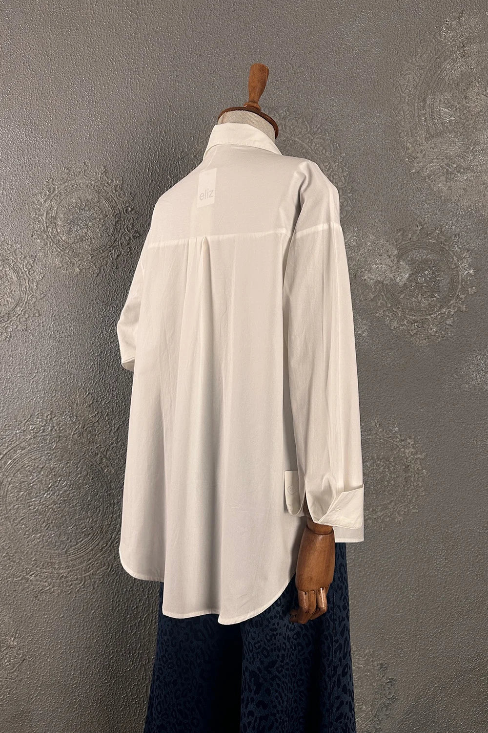 Beyaz oversize gömlek, kadın koleksiyonu, broş detaylı, uzun kollu, rahat kesim, yandan görünüm