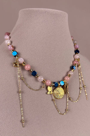 Doğal taş charm kolye, pembe ve mavi boncuklu, altın zincirli, detaylı çiçek ve spiral kolye detayları, kadın aksesuar, önden görünüm.