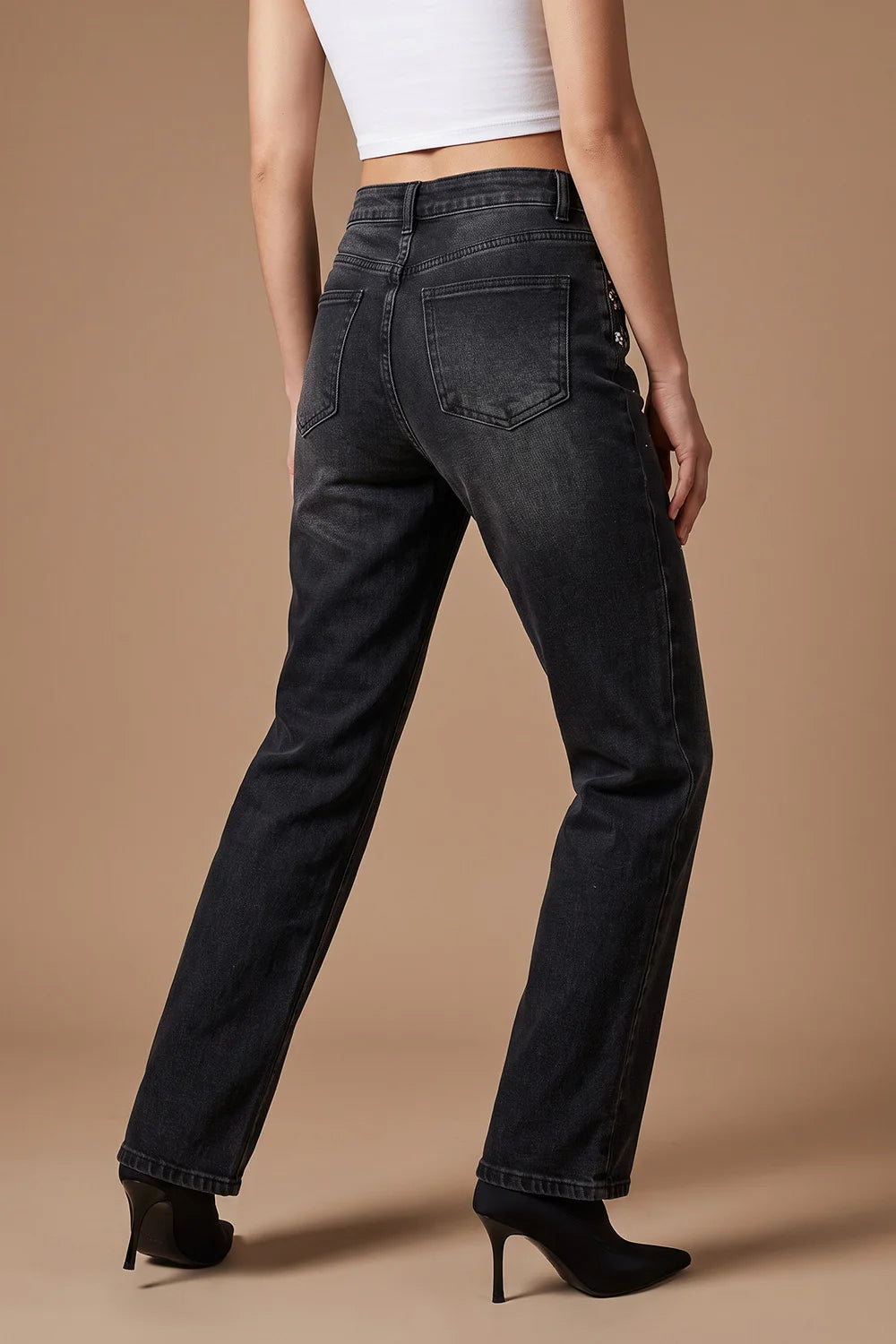 Siyah taşlamalı kadın jeans, yüksek bel, düz kesim, arka cep detaylı, yandan görünüm