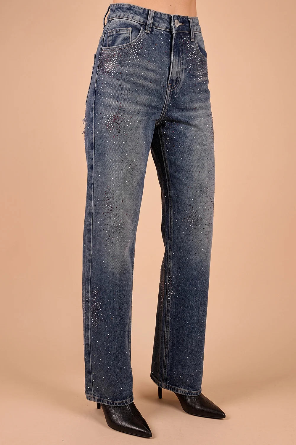 Taş işlemeli yırtık kadın jeans, koyu mavi denim, geniş kesim, siyah çizme ile stilize, önden görünüm.