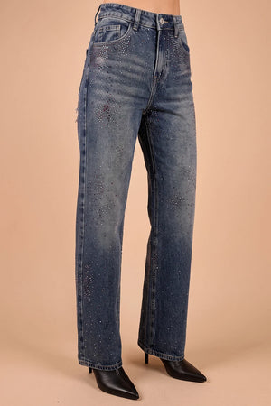Taş işlemeli yırtık kadın jeans, koyu mavi denim, geniş kesim, siyah çizme ile stilize, önden görünüm.