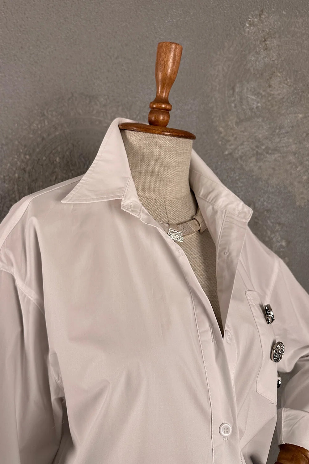 Beyaz oversize gömlek, broş detaylı, kadın giyim, klasik kesim, önden görünüm, şık ve rahat stil