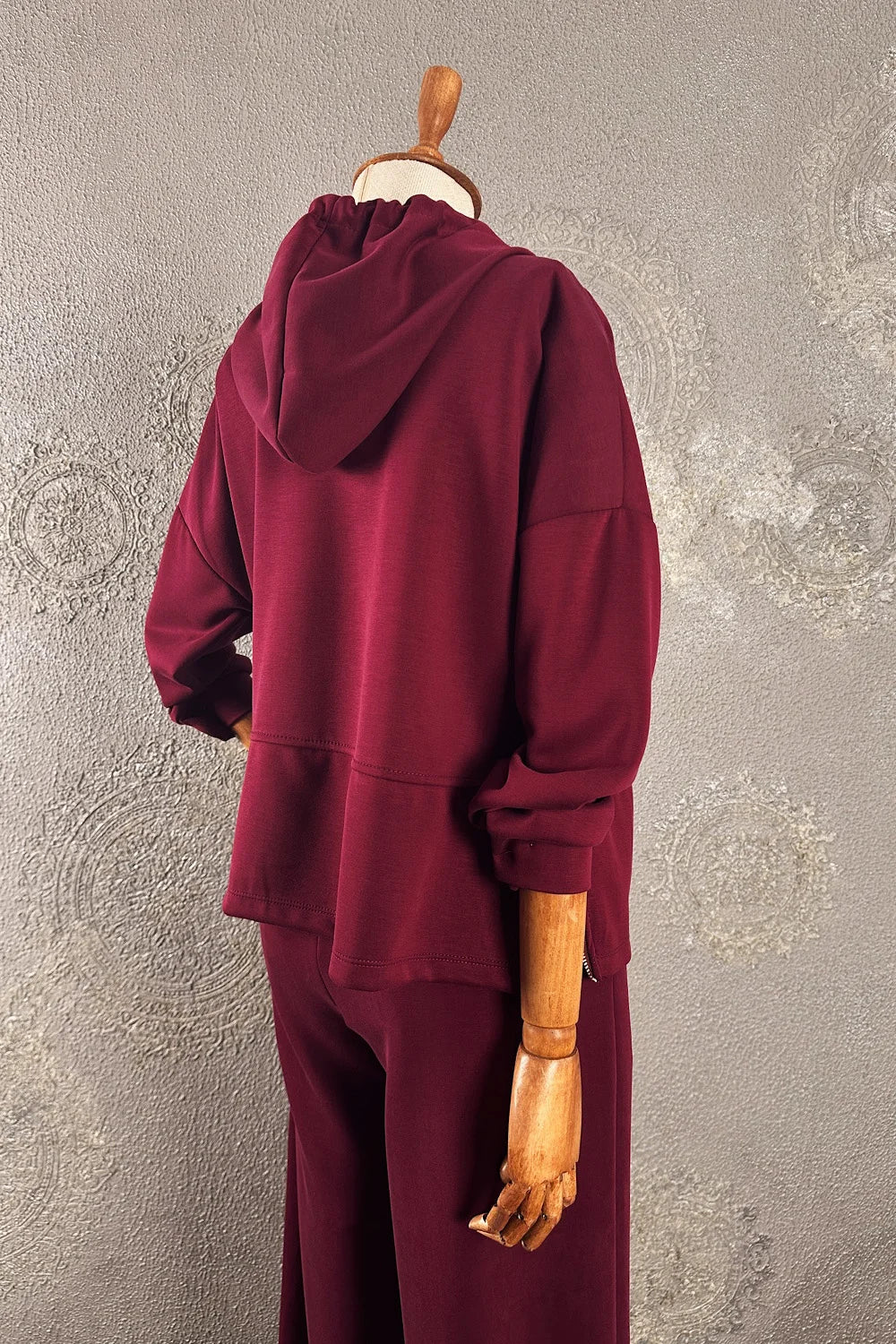 Bordo eşofman takımı, yumuşak dokulu, kapüşonlu, rahat kesim, kadın spor giyim, yandan görünüm