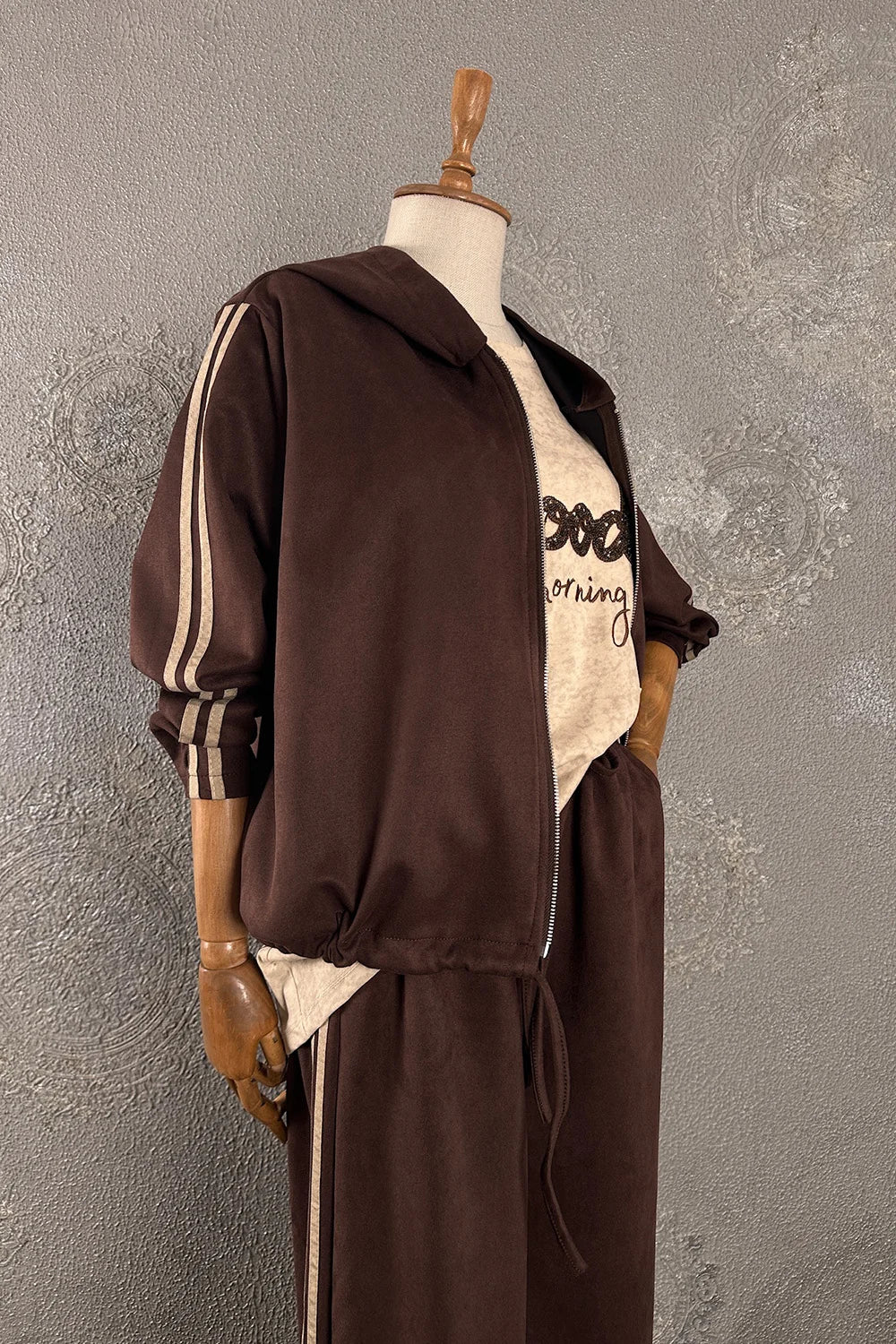 Kahverengi nubuk eşofman takımı, fermuarlı hoodie ve jogger pantolonlu, şeritli kollu, kadın spor giyim, yandan görünüm.