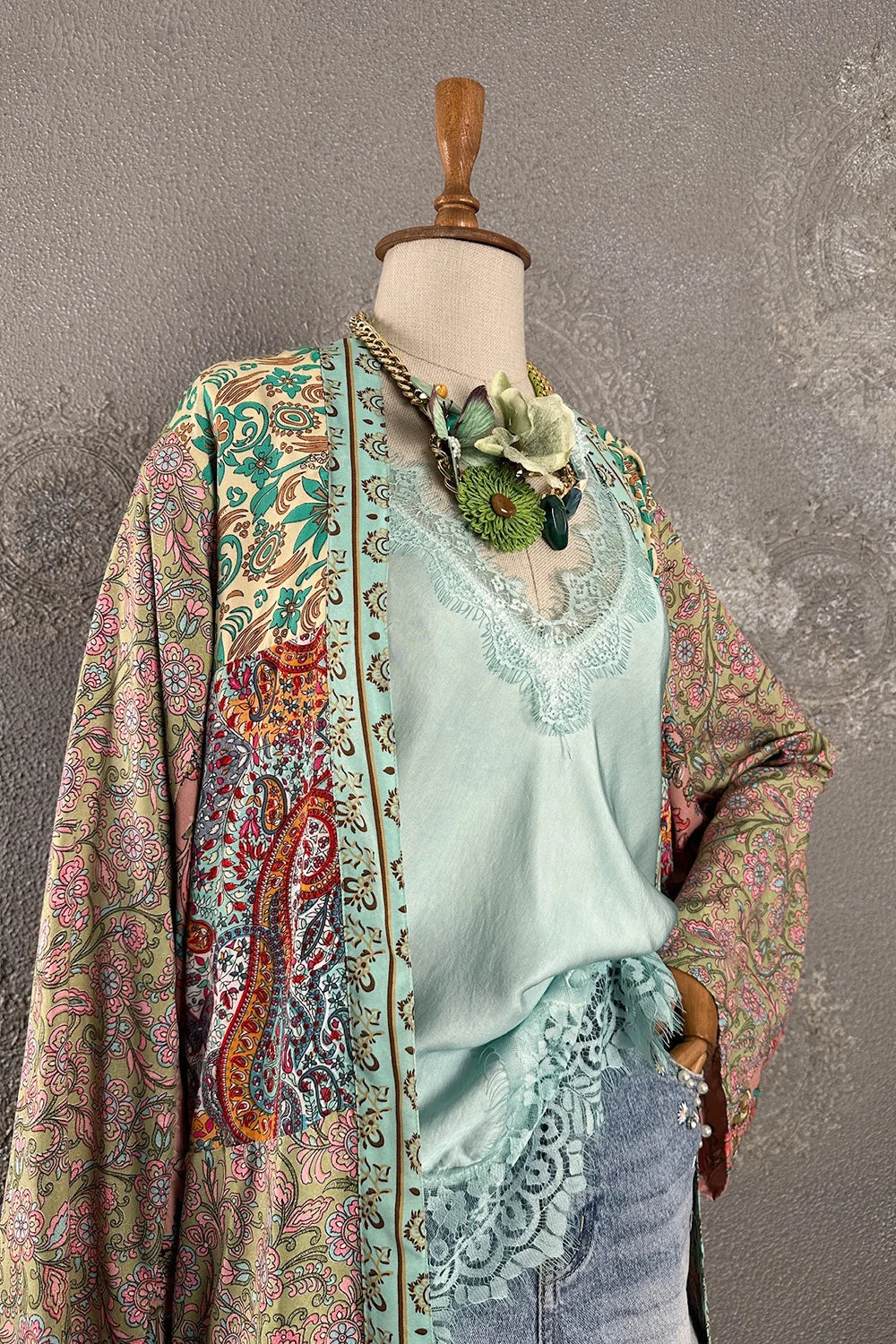 Açık mavi ipek kadın bluz, dantel detaylı, çiçek broş aksesuarlı, renkli kimono ceket kombinli, yandan görünüm