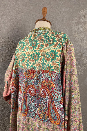 Renkli ipek kimono, çiçek ve paisley desenli, açık renk tabanında yeşil ve kırmızı tonlar, kadın oversize giyim, yandan görünüm.
